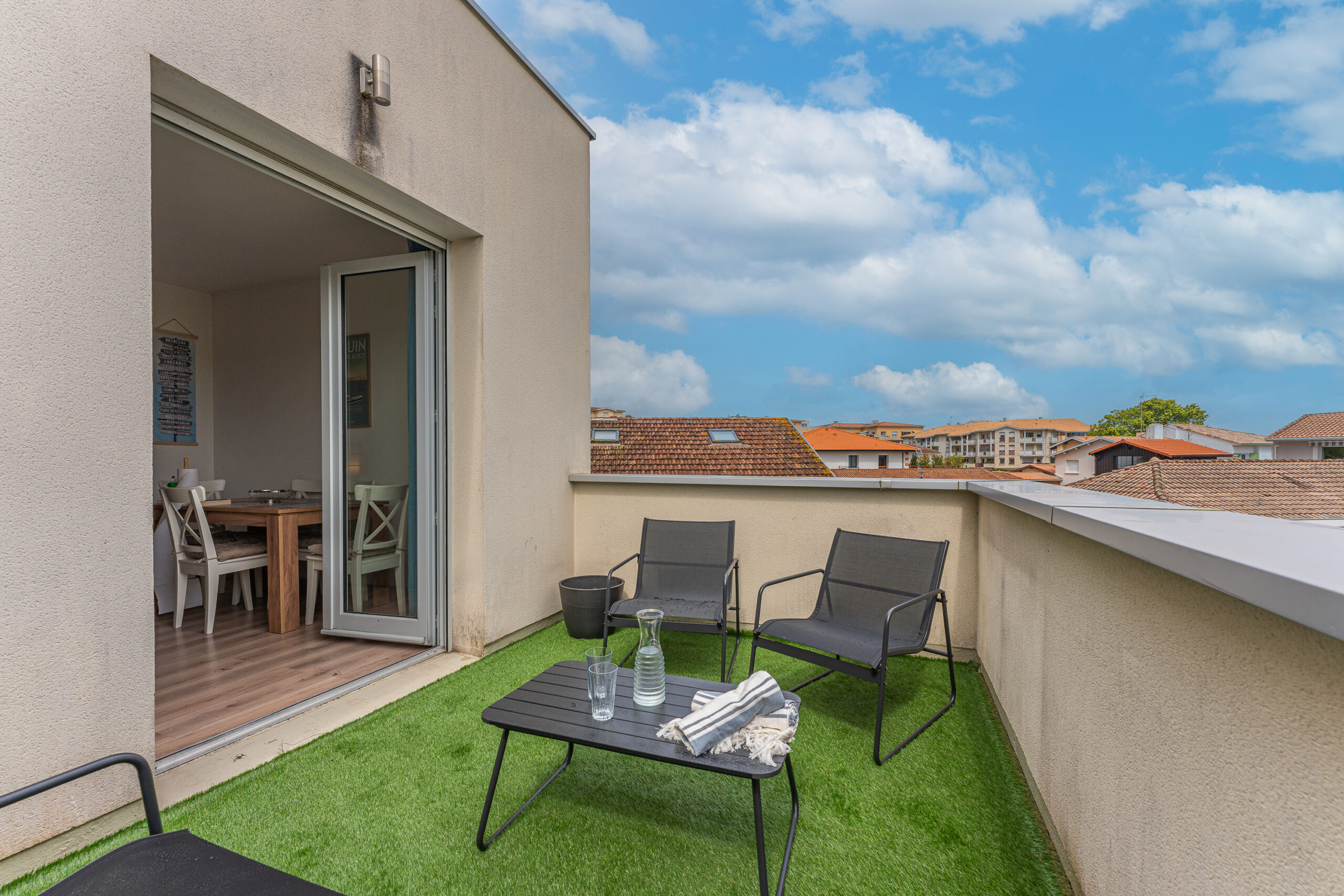 Vue de la terrasse de l'appartement, équipée d'un salon de jardin confortable, parfait pour profiter d'apéritifs en plein air ou de moments de détente. La terrasse est décorée et offre un espace privé et sans vis-à-vis, baigné de lumière naturelle, idéal pour savourer la douceur du climat du Bassin d'Arcachon.