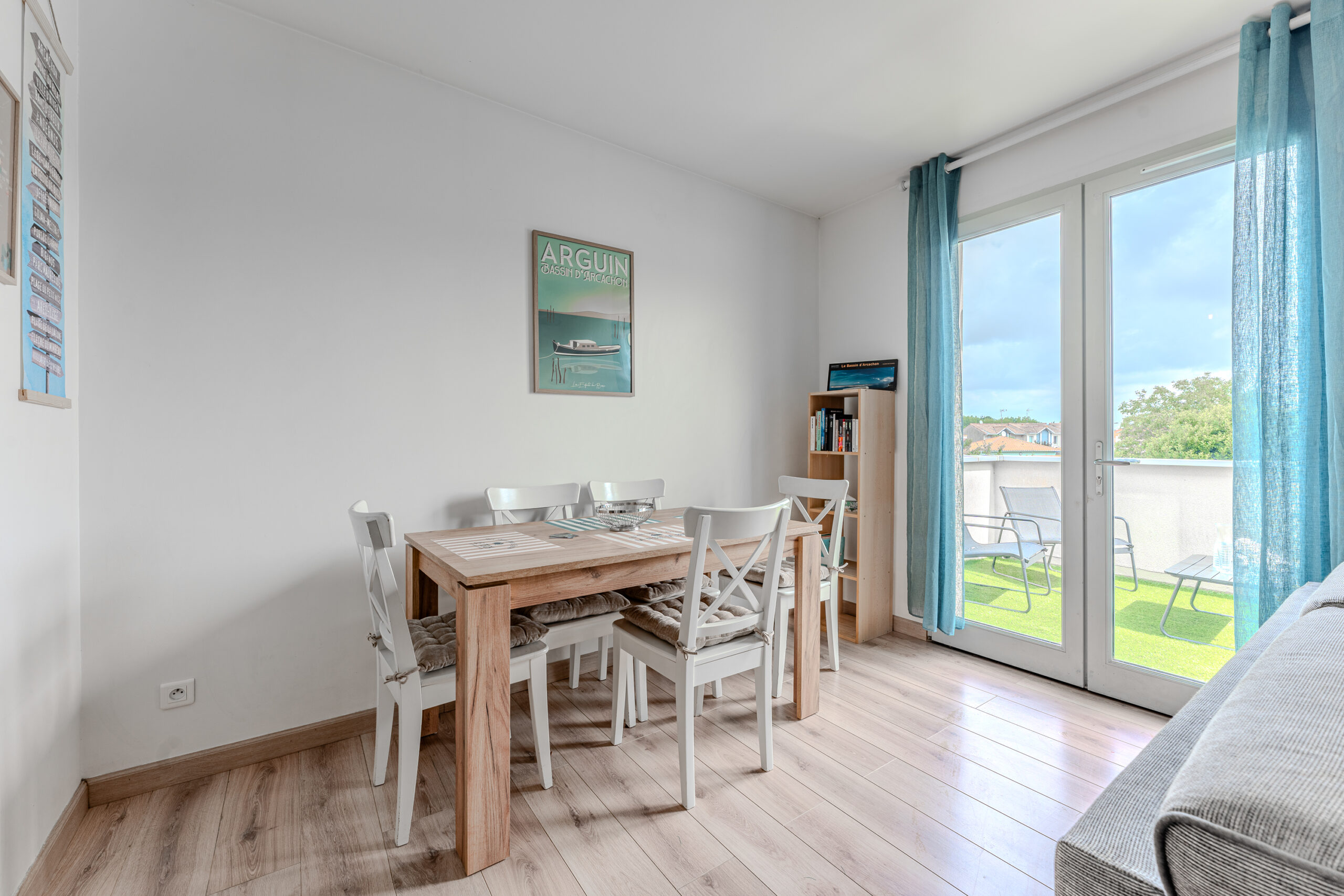 La salle à manger de notre appartement reflète l'esprit du Bassin d'Arcachon avec une décoration soigneusement choisie qui évoque le littoral et la nature environnante. Elle est équipée d'une table élégante qui invite à des repas conviviaux, entourée de chaises confortables sous un éclairage doux, créant une ambiance apaisante. Les touches de décoration marine et les matériaux naturels utilisés renforcent le lien avec la région, offrant un cadre idéal pour savourer des moments de partage tout en se sentant connecté à l'essence du Bassin.